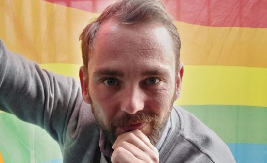 Christophe Ramont poseert voor regenboogvlag