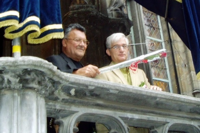 Foto van het huwelijk van William en zijn partner Rik. Ze staan op het balkon van het stadhuis te Gent en zwaaien